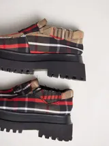 Mocasines rebeldes de plataforma, con diseño de cuadros marrón y azul, y detalles en cuero. Cuenta con elásticos invisibles para un fácil calzado.