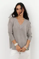 Sweater de tejido de punto fino con brillo metálico, color verde lima. Presenta escote en V y mangas largas.