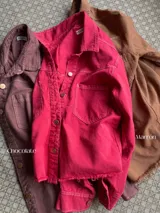 Camisa color marrón de denim liviano con fit suelto, cuello clásico, cierre frontal con botones, dos bolsillos con solapa en el pecho y ruedo desflecado.