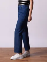 Jean elastizado de corte recto, color azul denim, con pretina con pasadores, botón y cierre. Tiene tres bolsillos delanteros y dos bolsillos traseros.