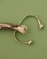 Brazalete rígido abierto de bronce con forma de herradura.