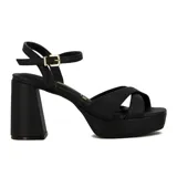 Sandalia de mujer color blanco con plataforma y taco ancho y alto. Presenta tiras anchas cruzadas sobre el empeine y una tira fina con hebilla ajustable en el tobillo.