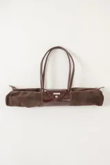 Bolso de viaje en gamuza azul, con asas de cuero y amplio compartimento principal.