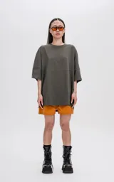 Remera de manga corta color verde militar, con calce extra oversize y un recorte horizontal que atraviesa el pecho y la espalda.