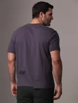 Remera gris con cuello redondo y mangas cortas. Estampado frontal con diseño gráfico que imita un sello de la ciudad de Nueva York.