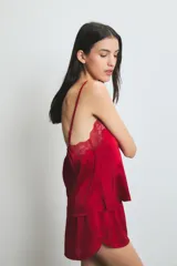 Conjunto de pijama de satén rojo, compuesto por un top con breteles finos y detalle de encaje en el escote, y un short con cintura elástica.