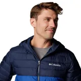 Campera acolchada con capucha, de dos tonos: azul oscuro en la parte superior (hombros y mangas) y azul eléctrico en el torso. Presenta cierre frontal y bolsillos laterales con cremallera.