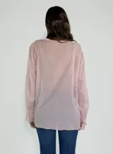 Camisa celeste de mangas 3/4 con volados en el frente y cuello en V.