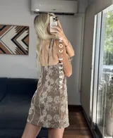 Vestido corto marrón con estampado de flores blancas, escote en V y tirantes finos.
