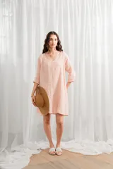 Vestido corto de lino color rosado, corte ancho y mangas 3/4, con escote en V.