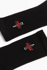 Medias negras de caña alta con logo de Coca-Cola bordado en rojo y blanco.