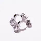 Par de aros colgantes plateados con un cristal redondo engarzado en una estructura que permite el movimiento.