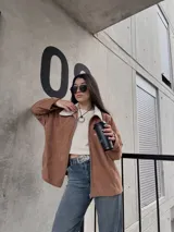 Campera marrón de pana con cierre frontal, cuello de piel sintética y bolsillos laterales.