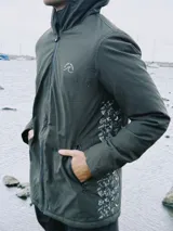 Campera verde oscuro con estampado de dibujos en blanco en el frente. Corte recto, con cierre frontal y bolsillos laterales con cierre.