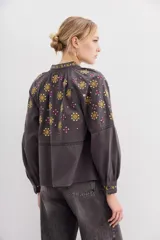 Camisa gris de algodón con bordados florales dorados y fucsias, lentejuelas y detalles de puntilla en mangas.