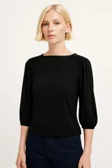 Remera color marfil con cuello redondo y mangas 3/4 abullonadas.