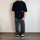 Pantalón jean celeste de corte holgado con múltiples bolsillos tipo cargo.