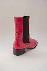 Botas de cuero rojas con elástico negro en los laterales, punta cuadrada y taco bajo.
