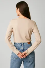 Remera de manga larga confeccionada en algodón de color blanco, con cuello redondo y un bolsillo aplicado en el pecho. Presenta un diseño de calce al cuerpo.