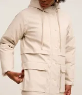 Campera parka color beige, forrada con peluche sintético, confeccionada en poliuretano. Tiene capucha, ajuste en el cuello, cierre delantero, bolsillos delanteros con solapa y textura gomosa.
