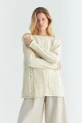 Sweater color crema de tejido de punto con detalle de trenzas en el frente y mangas, cuello redondo y terminación enrulada en cuello, puños y ruedo. Tejido en 100% lana fina sin teñir.