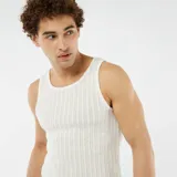 Musculosa blanca de tejido calado con cuello redondo y sisas amplias.