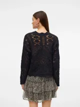 Sweater de punto negro con calados, mangas largas abullonadas y cuello redondo.