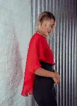 Capa corta color verde esmeralda de gasa transparente, con cuello redondo y abertura frontal con cierre de botón.