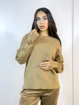 Sweater color camel de tejido de punto con cuello redondo y mangas largas. Presenta detalle de botones dorados en los puños y en los hombros.