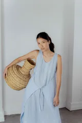 Vestido midi gris oscuro de lino, corte recto y sin mangas. Tiene bolsillos laterales y cuello redondo.