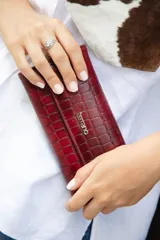 Monedero de simil cuero color verde agua, con cierre de broche imantado. Interior con tarjetero y lugar para billetes, y bolsillo interno con cierre.