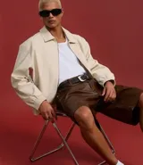 Bermuda masculina de cuero sintético color marrón, corte holgado, con cintura con trabillas, cierre tradicional, bolsillos delanteros y traseros, y efecto desteñido.