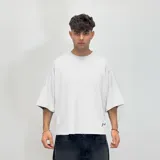 Remera blanca de corte boxy con la palabra 'nenefa' estampada en cursiva en la espalda.