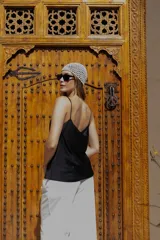 Musculosa de poliéster color blanco, con escote drapeado y breteles finos.