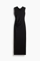 Vestido largo negro de punto elástico con leve brillo, corte entallado, escote drapeado, espalda escotada y pliegues laterales.