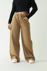 Pantalón jean color café, de tiro medio y pierna ancha.