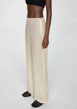 Pantalón de vestir color crudo, de corte recto y tiro medio, con cierre lateral de cremallera.