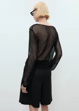 Jersey de punto calado negro con cuello barco y detalles florales bordados.