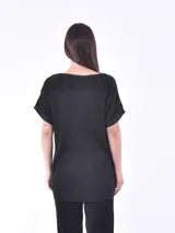 Blusa negra de corte holgado y mangas cortas, con textura plisada.