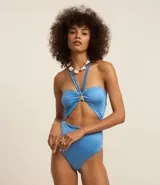 Malla enteriza celeste de microfibra brillante, con escote halter, recorte en el abdomen y adorno de estrella dorada.