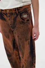Pantalón jean slouchy de tiro medio, estilo mom, color marrón con efecto lavado.
