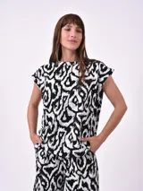 Remera negra con estampado abstracto en blanco.