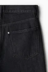 Pantalón de jean negro de tiro alto, corte relajado y pierna ancha.