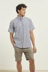 Camisa de manga corta a rayas verticales azules y blancas, con cuello abotonado y bolsillo en el pecho.