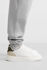 Zapatillas deportivas blancas con detalle en color gris en el talón y suela con plataforma.