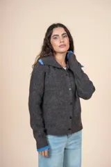 Cárdigan de tejido con relieve color gris, con cuello camisero, botones al frente y detalles de color celeste en cuello y puños.