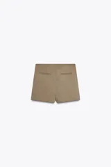 Falda pantalón color beige de tiro medio con diseño asimétrico.