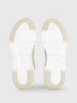Zapatillas urbanas color beige, confeccionadas en cuero y tela, con suela blanca y cordones. Presentan monograma de la marca en el lateral.