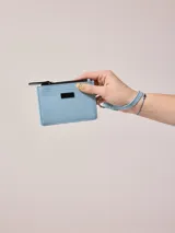 Billetera azul de poliuretano con cierre y correa de mano.