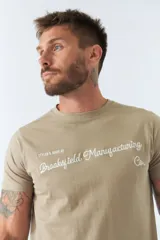 Remera color arena con cuello redondo y logo bordado en el pecho.